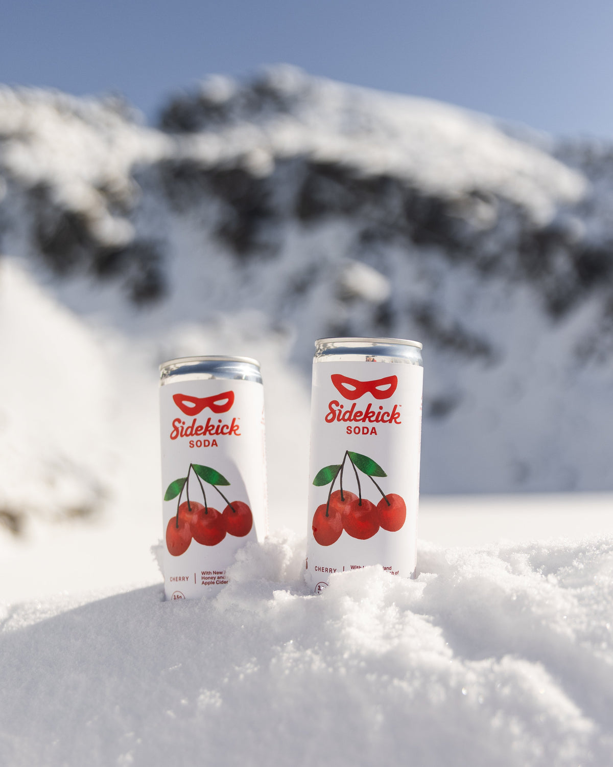 Cherry Sidekick Soda in the snow with the Southern Alps behind