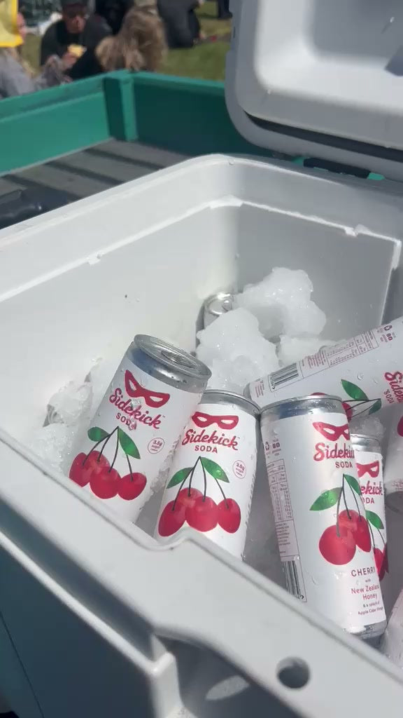 Sidekick Cherry cans on ice in a chilly bin